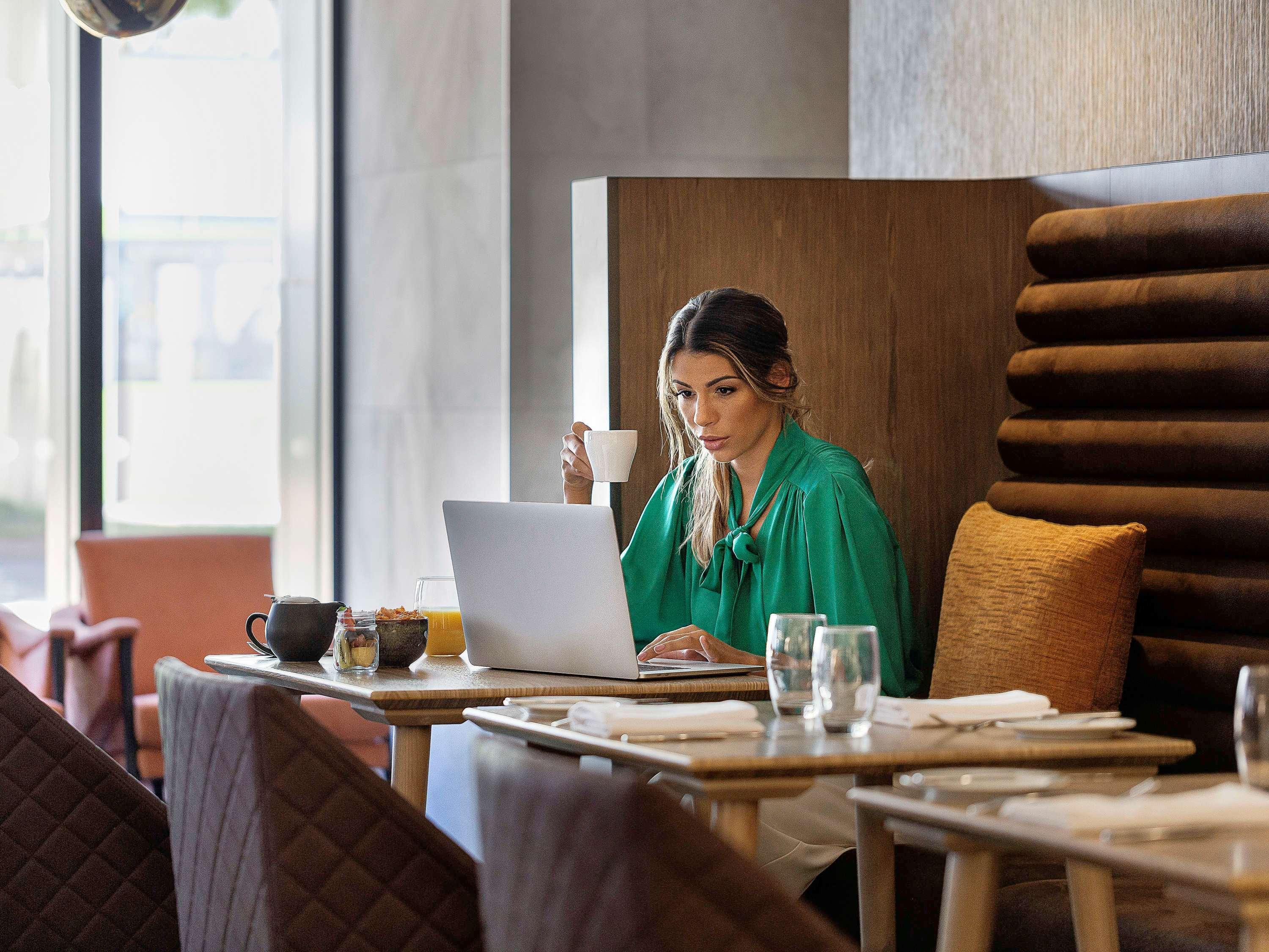 ホテル プルマン ロトルア エクステリア 写真 A woman working on a laptop